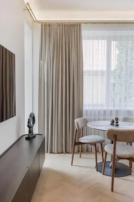 a dining room with a table and chairs and a window at SongInn Deco Apartment in Kaunas