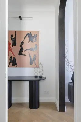 a table in a room with a painting on the wall at SongInn Deco Apartment in Kaunas