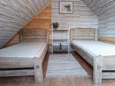 two beds in a room with wooden walls at Cozy stay in village