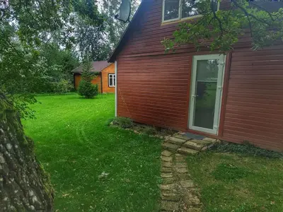a red house with a yard next to a building at Cozy stay in village