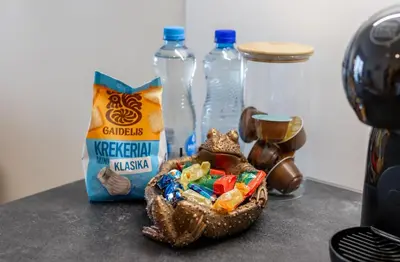 a bowl of candy and bottles of milk on a counter at Vincent Sunlight Stay - Near Clinic, Arena and Stadium in Kaunas