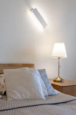 a bedroom with a bed with a lamp and a pillow at Vincent Sunlight Stay - Near Clinic, Arena and Stadium in Kaunas