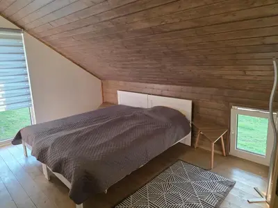a bedroom with a bed in a room with wooden walls at Friend's homestead