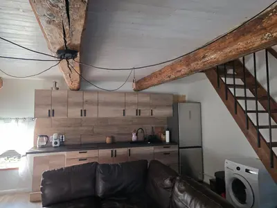 a living room with a couch and a kitchen at Friend's homestead