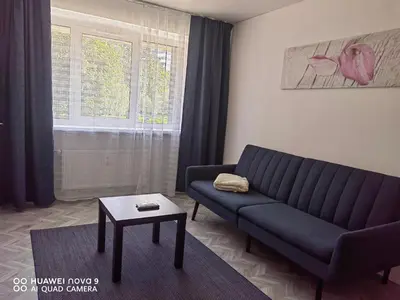 a living room with a couch and a table at Next door airport apartment in Karmėlava