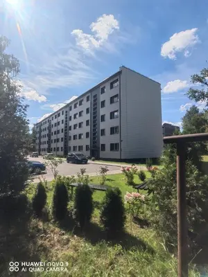 a largeartment building in a parking lot at Next door airport apartment in Karmėlava