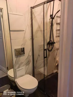a bathroom with a toilet and a glass shower at Next door airport apartment in Karmėlava