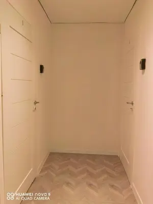 an empty room with two doors and a wooden floor at Next door airport apartment in Karmėlava