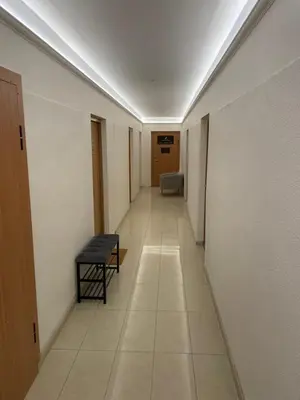 a long hallway with a bench and a table at Suite in the heart of the city in Panevėžys