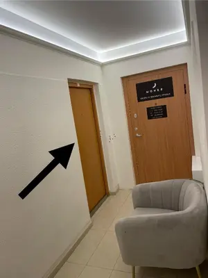a room with an arrow pointing to a door and a chair at Suite in the heart of the city in Panevėžys