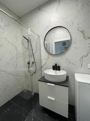 a bathroom with a sink and a mirror at Suite in the heart of the city in Panevėžys
