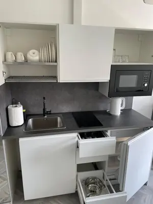 a small kitchen with a sink and a microwave at Suite in the heart of the city in Panevėžys