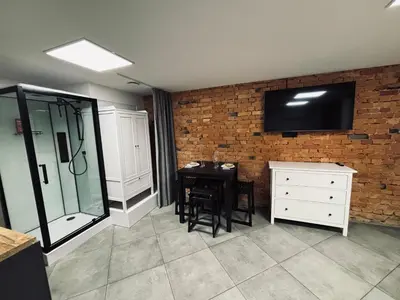 a kitchen with a table and a tv on a brick wall at 69 apartaments II in Panevėžys