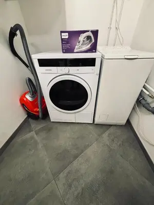 a washing machine with a vacuum and a box on top of it at 69 apartaments II in Panevėžys