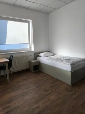 a small bedroom with a bed and a window at Apartamentai1 in Utena