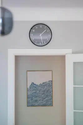 a clock on top of a white door at Vokieciu st Apt with Balcony I In the Center of it All I cohost in Vilnius