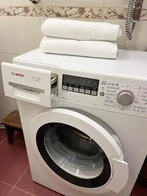 a white washing machine with towels on top of it at Vokieciu st Apt with Balcony I In the Center of it All I cohost in Vilnius