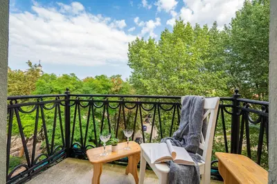 a balcony with a table and two glasses of wine at Vokieciu st Apt with Balcony I In the Center of it All I cohost in Vilnius