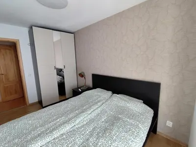 a bedroom with a bed with a black headboard at Jaukūs apartamentai in Vilnius