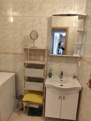 a small bathroom with a sink and a mirror at Jaukūs apartamentai in Vilnius