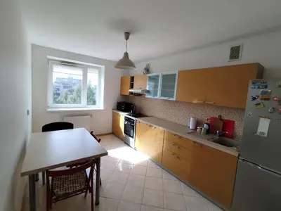 a kitchen with a table and a refrigerator and a table and a table sidx sidx at Jaukūs apartamentai in Vilnius