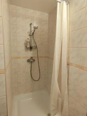 a bathroom with a shower with a shower curtain at Jaukūs apartamentai in Vilnius