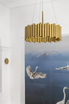 a chandelier hanging in a room with birds on the wall at Blue Old Town apartment in Vilnius