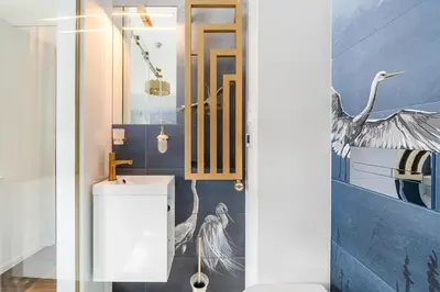 a bathroom with a bird mural on the wall at Blue Old Town apartment in Vilnius