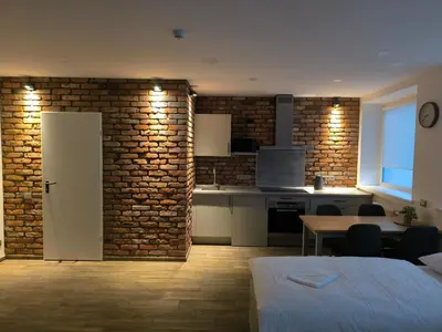 a kitchen and dining room with a brick wall at Studio3 in Utena
