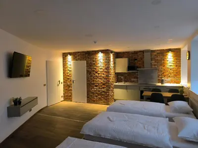 a living room with two beds and a kitchen at Studio3 in Utena
