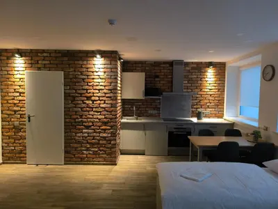 a kitchen and dining room with a brick wall at Studio3 in Utena