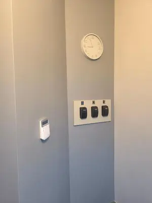 a clock on a wall next to a wall with switches at Studio3 in Utena