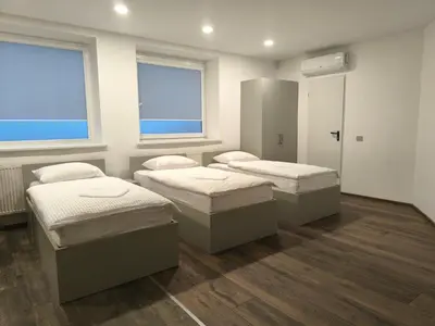 two beds in a room with two windows at Studio3 in Utena