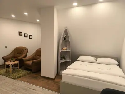a bedroom with a bed and two chairs at Studio 2 in Utena