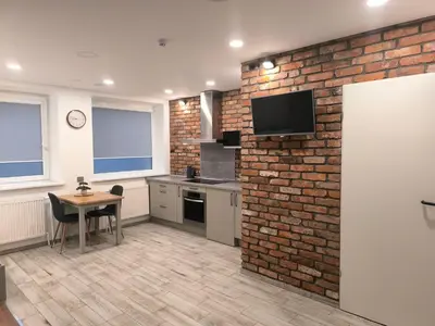 a kitchen with a brick wall and a table at Studio 2 in Utena