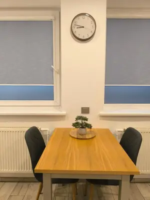 a dining room table with chairs and a clock on the wall at Studio 2 in Utena