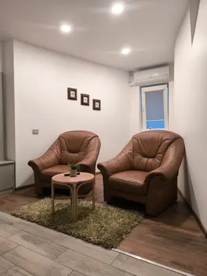 two leather chairs and a table in a room at Studio 2 in Utena