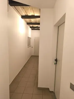 an empty hallway with white walls and a tile floor at Studio 2 in Utena