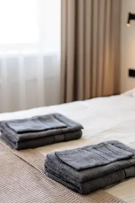 two towels sitting on top of a bed at Alėjos apartamentai in Šiauliai