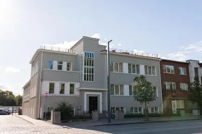 a white building on the side of a street at Alėjos apartamentai in Šiauliai