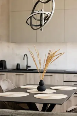 a kitchen with a table with plates and a chandelier at Alėjos apartamentai in Šiauliai