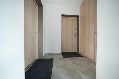 an empty hallway with wooden doors and a tile floor at Sodų Vilos in Kaunas