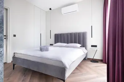 a bedroom with a large bed with white sheets at Sodų Vilos in Kaunas
