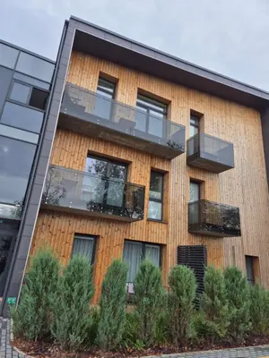 an apartment building with balconies and trees at Neveikia in Pakopi