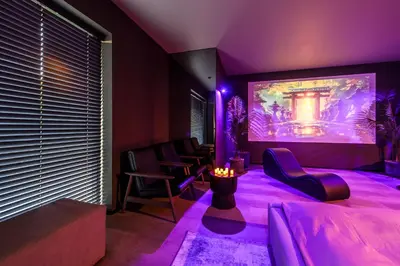 a purple room with chairs and a large screen at Jacuzzi Cinema Japandi 2 in Kaunas