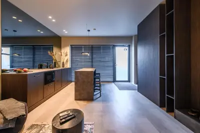 a kitchen with wooden cabinets and a counter top at Jacuzzi Cinema Japandi 2 in Kaunas