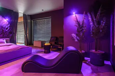 a bedroom with purple lighting and a bed and plants at Jacuzzi Cinema Japandi 2 in Kaunas