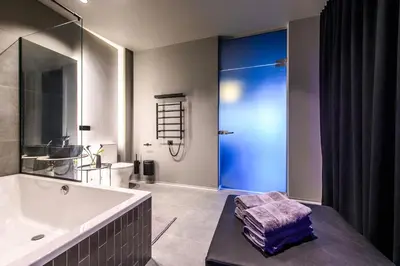 a bathroom with a tub and a sink and a shower at Jacuzzi Cinema Japandi 2 in Kaunas