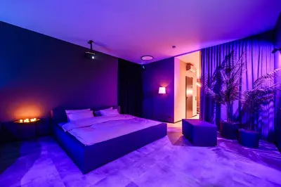 a purple bedroom with a bed and a plant at Jacuzzi Cinema Wabi Sabi 3 in Kaunas