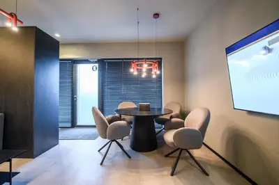 a meeting room with a table and chairs and a screen at Jacuzzi Cinema Wabi Sabi 3 in Kaunas